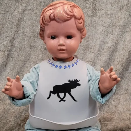 Haklapp med älg-tryck på docka