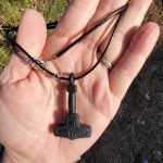 Torhammare nyckelring och halsband på träbänk 1080